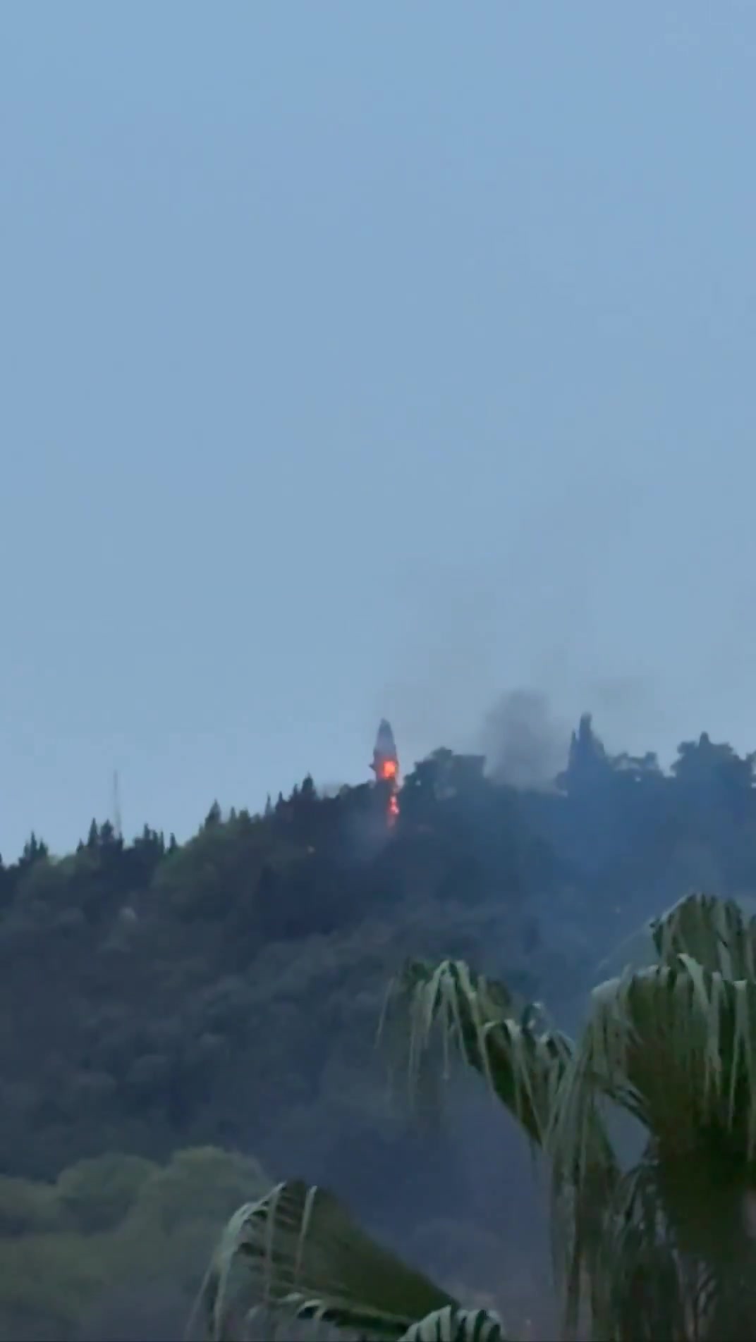 Smoke and fire are seen on top of a hill in the northern city of Behshahr in the early hours of Friday after a strike targeting a radar site