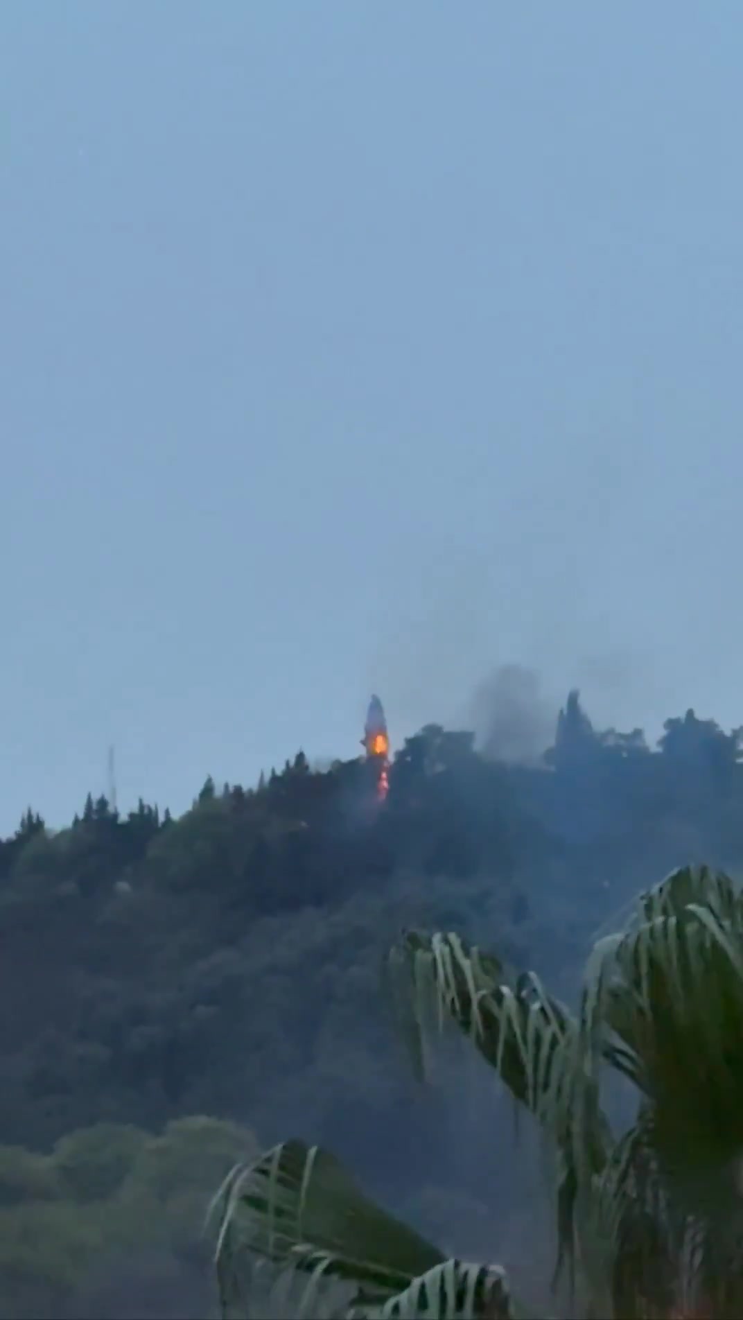 Smoke and fire are seen on top of a hill in the northern city of Behshahr in the early hours of Friday after a strike targeting a radar site