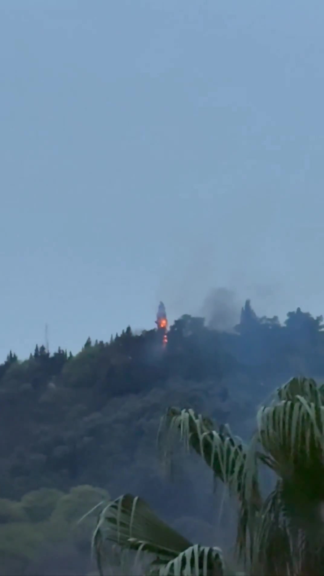 Smoke and fire are seen on top of a hill in the northern city of Behshahr in the early hours of Friday after a strike targeting a radar site