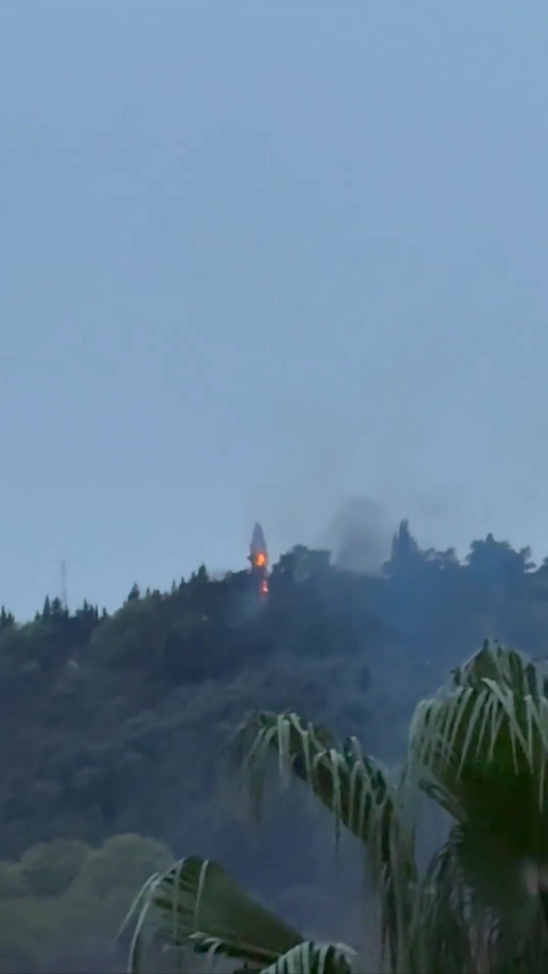 Smoke and fire are seen on top of a hill in the northern city of Behshahr in the early hours of Friday after a strike targeting a radar site