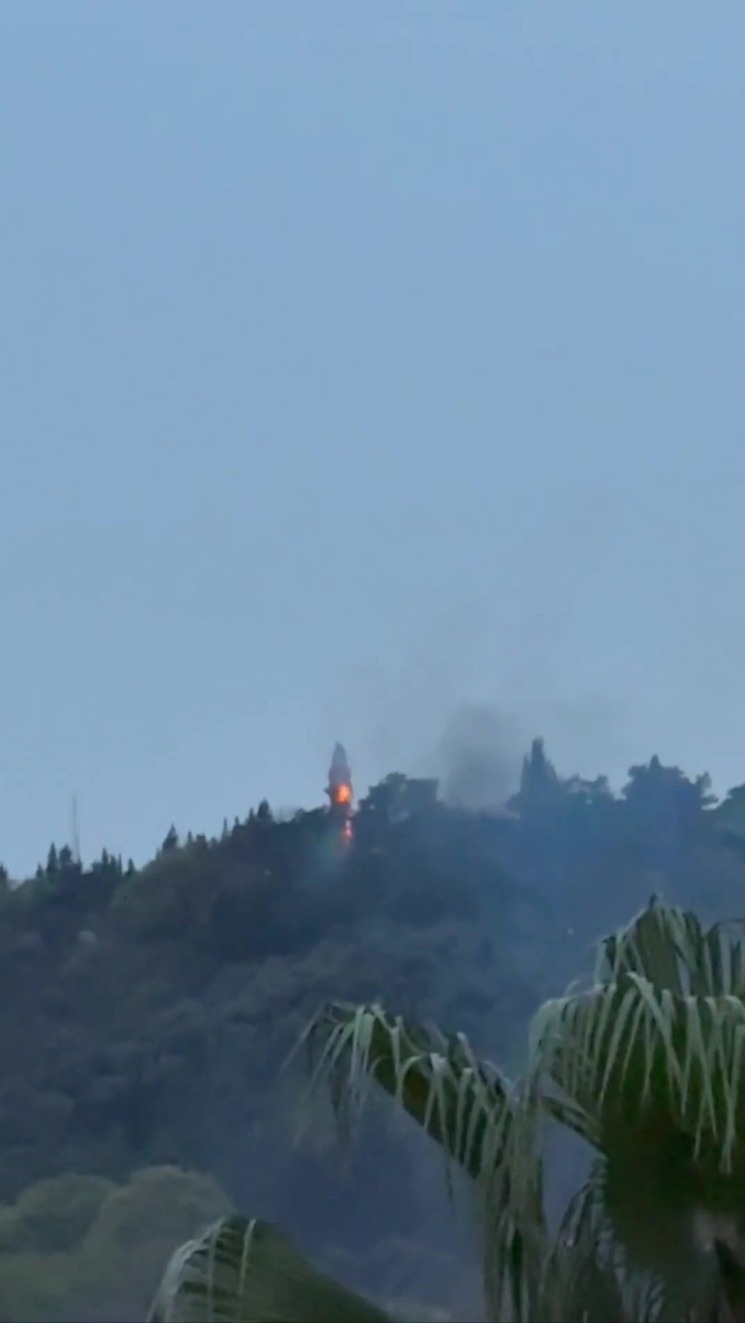 Smoke and fire are seen on top of a hill in the northern city of Behshahr in the early hours of Friday after a strike targeting a radar site
