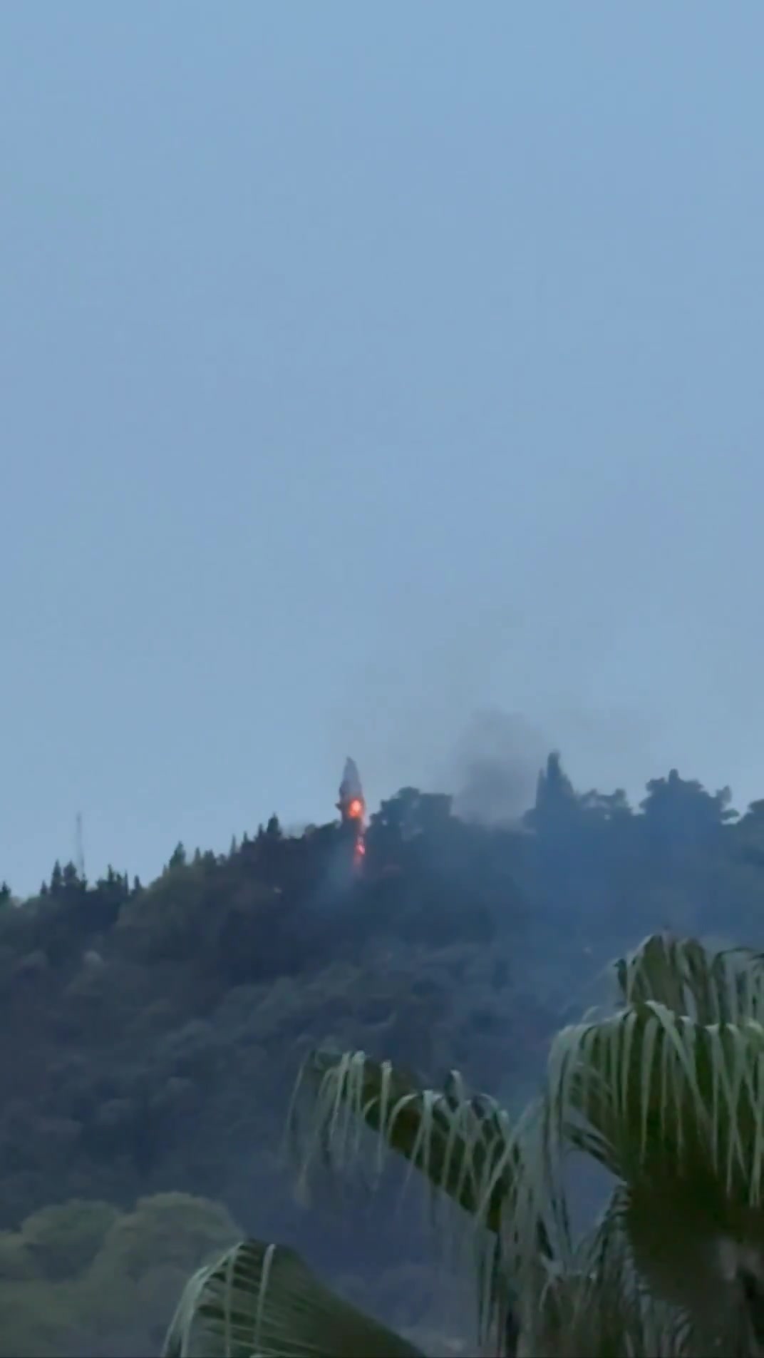 Smoke and fire are seen on top of a hill in the northern city of Behshahr in the early hours of Friday after a strike targeting a radar site