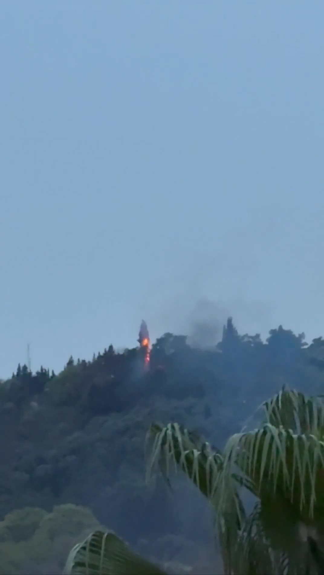 Smoke and fire are seen on top of a hill in the northern city of Behshahr in the early hours of Friday after a strike targeting a radar site