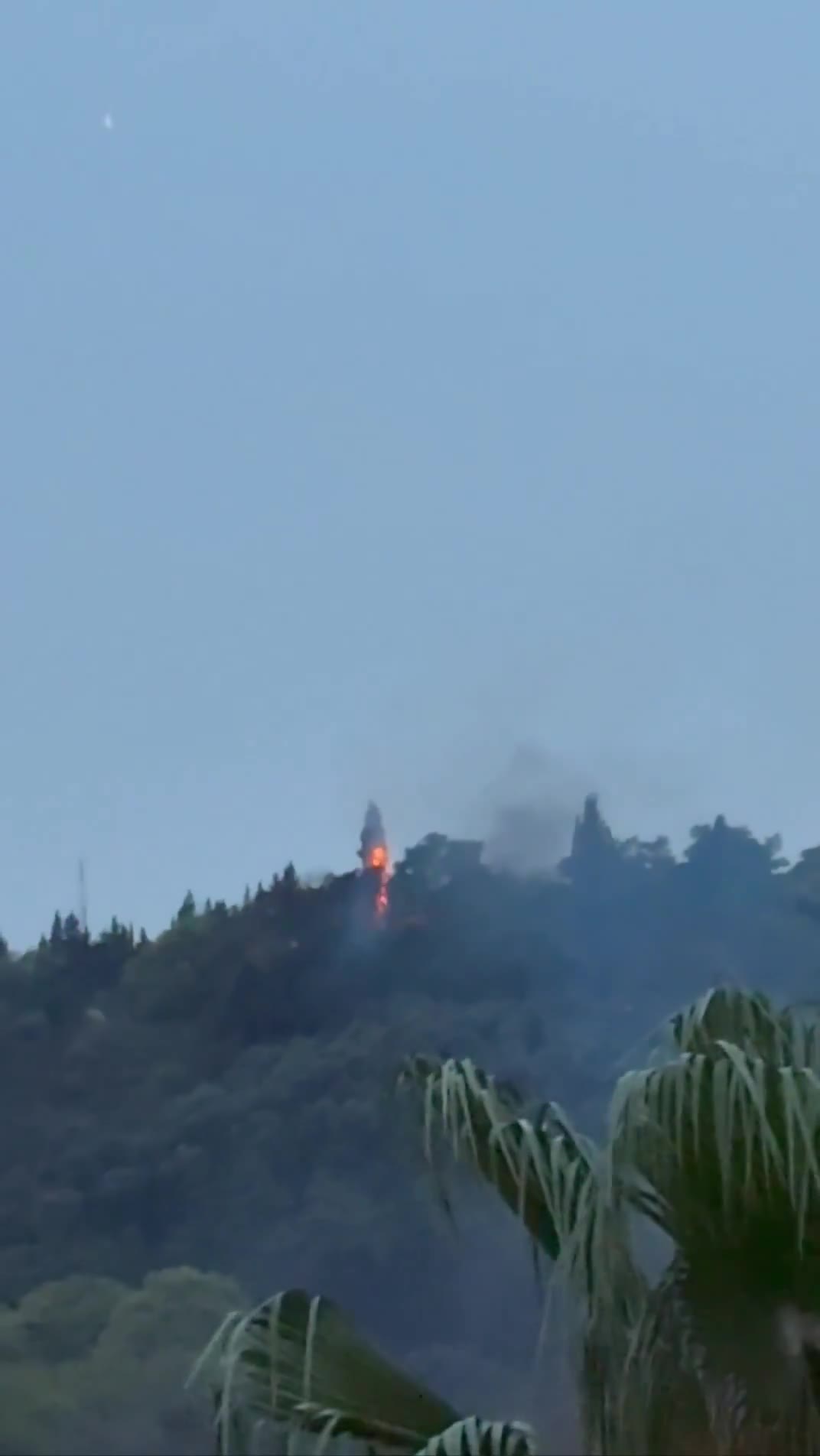 Smoke and fire are seen on top of a hill in the northern city of Behshahr in the early hours of Friday after a strike targeting a radar site
