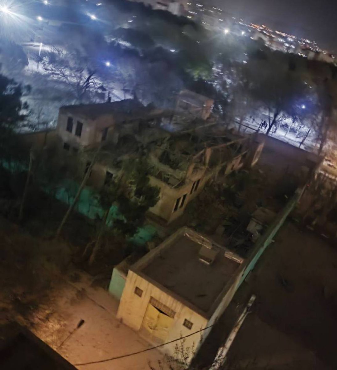 Residents in the Bisim district in south-east Tehran inspect the aftermath of a strike targeting the local police station, the roof of which appears to have been destroyed