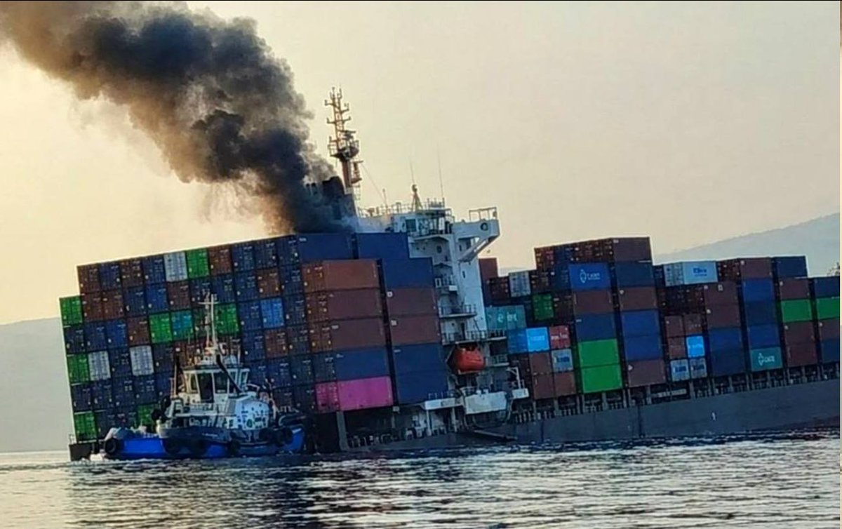 Images emerging on social media appear to show container ship GFS PRIDE partially submerged and smoking as a tugboat manoeuvrers it from the stern